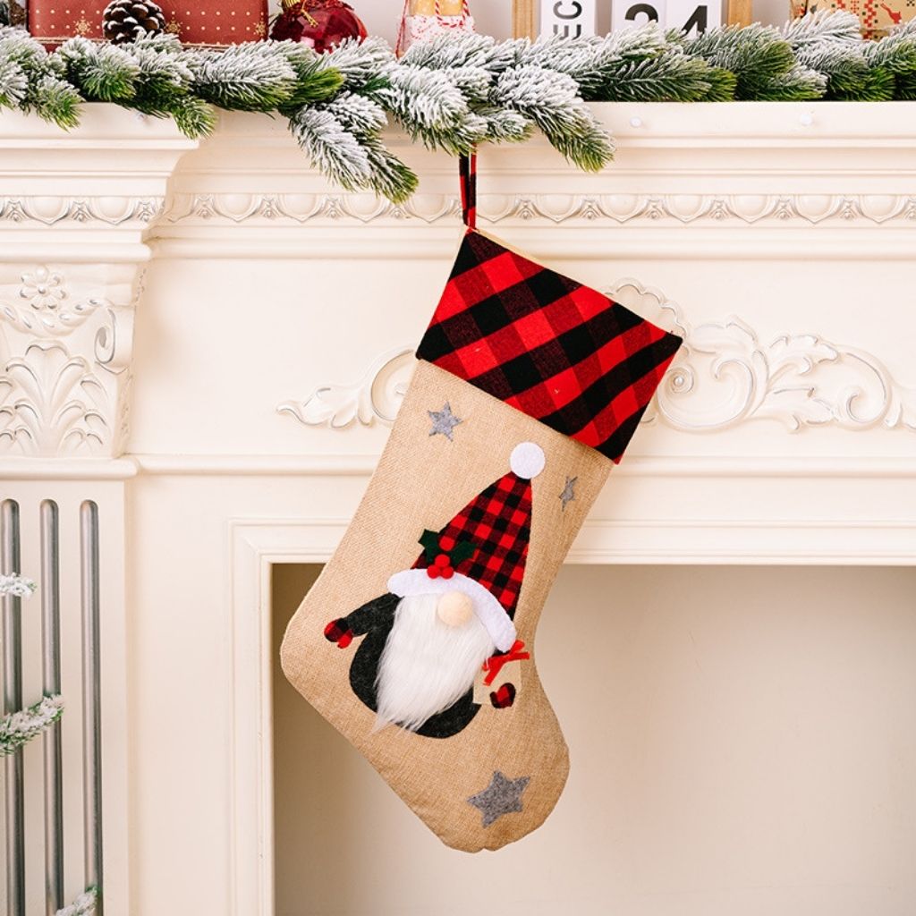 Christmas stocking with a gnome design hanging on a fireplace mantel.