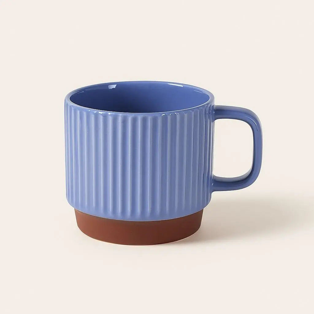 Blue ceramic mug with ribbed design on a beige background