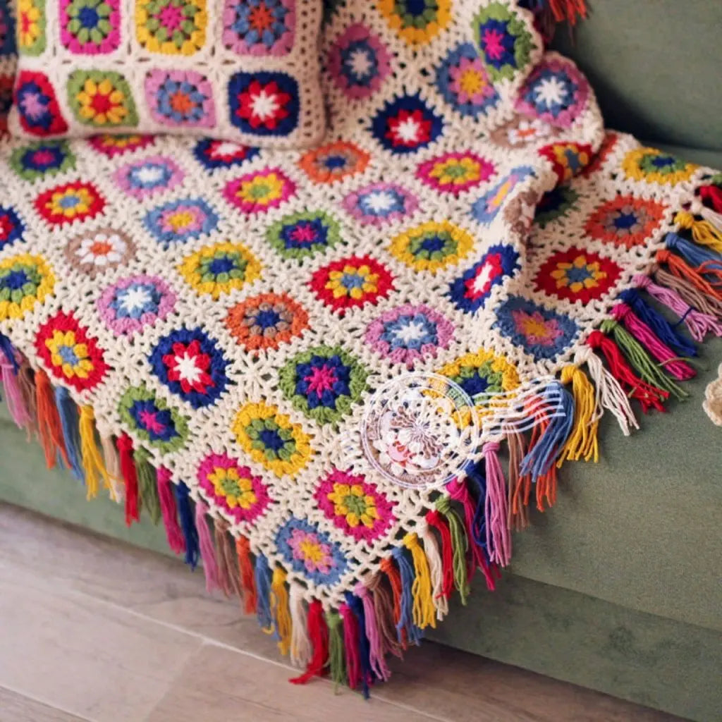 Floral motif blanket with hand crocheted design and vibrant decorative tassel details