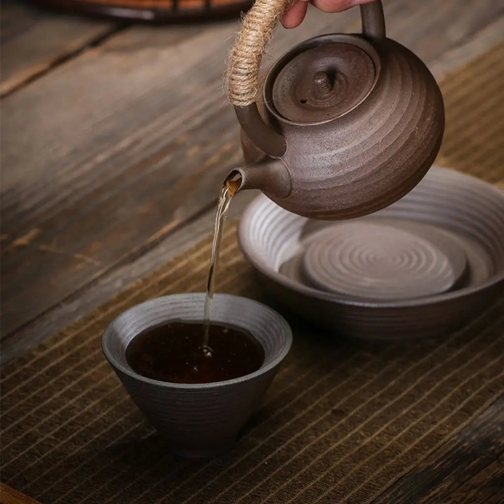 Handmade ceramic tea brewing vessel with sturdy pottery construction and comfortable grip handle