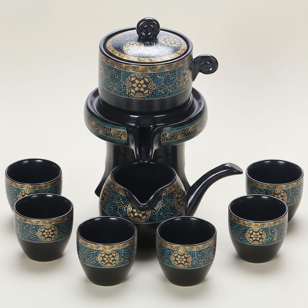Ceramic teapot with matching cups featuring golden detailing on black glaze finish