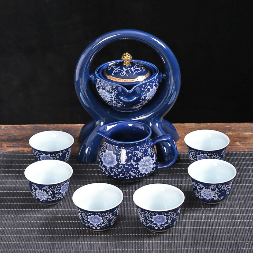 Ceramic rotating teapot on wooden stand with serving pot and teacups