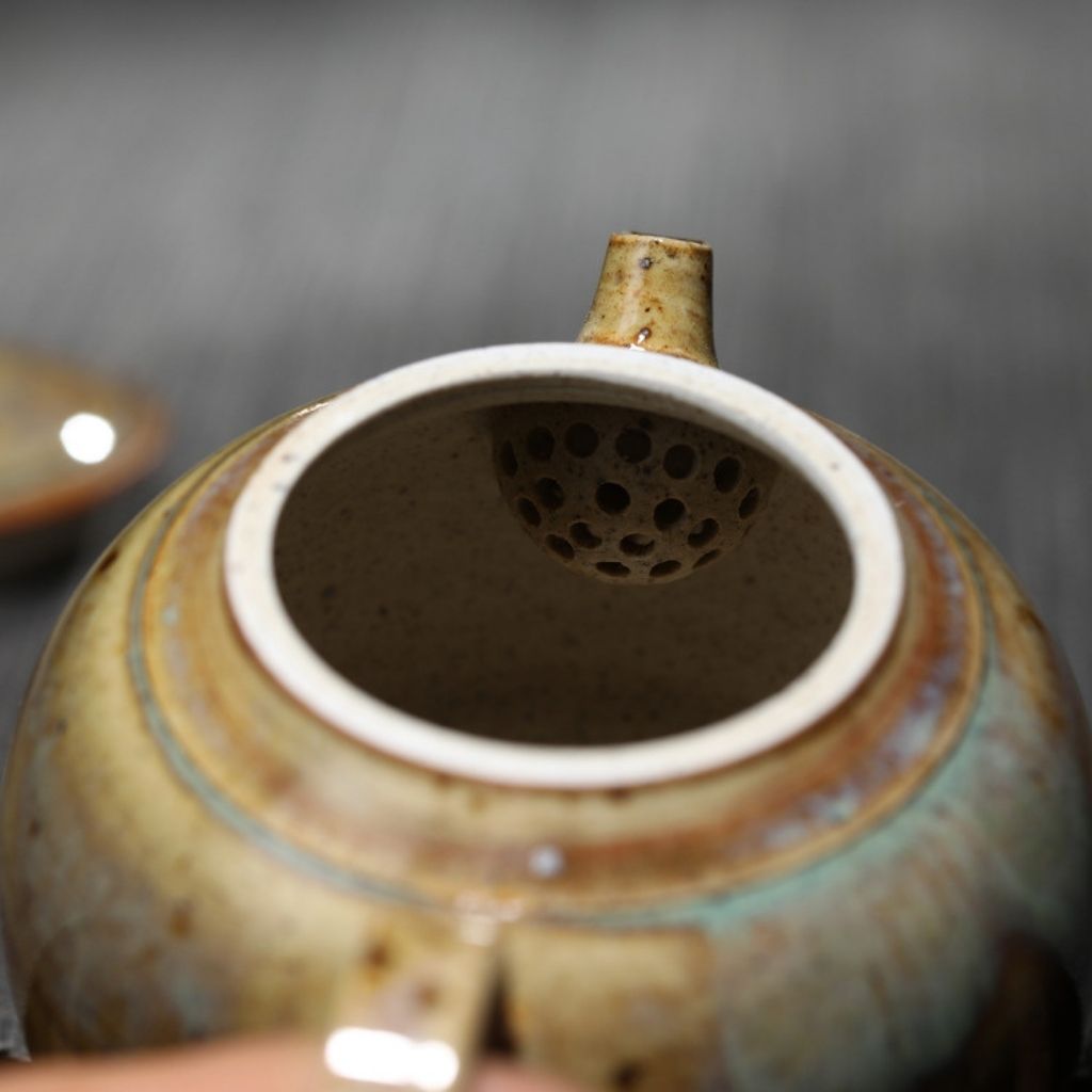 Artisan ceramic teapot with curved handle and smooth pouring spout in earth tones