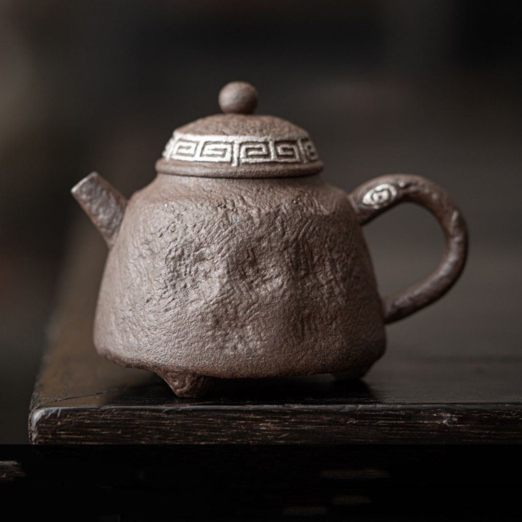 Artisan stoneware teapot handle showcasing bronze moss glaze and handcrafted ceramic detailing