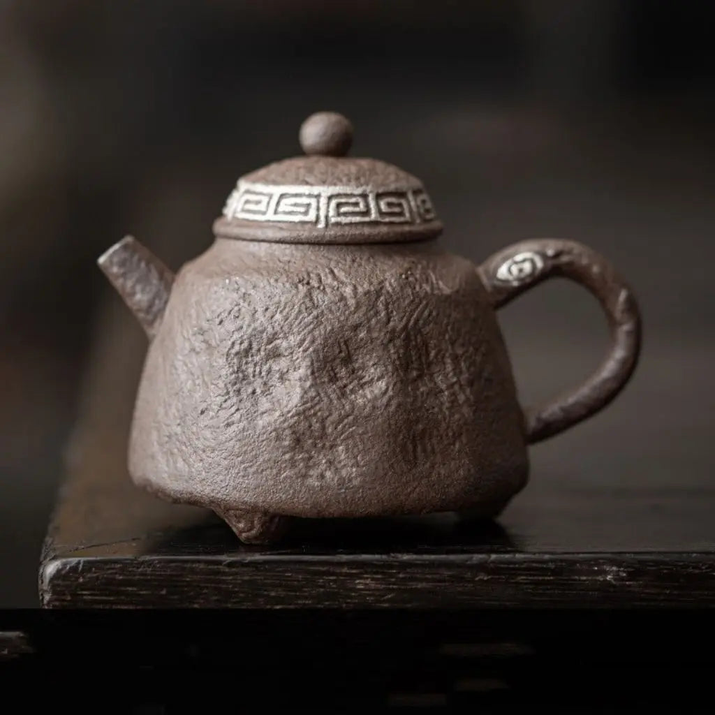 Artisan stoneware teapot handle showcasing bronze moss glaze and handcrafted ceramic detailing