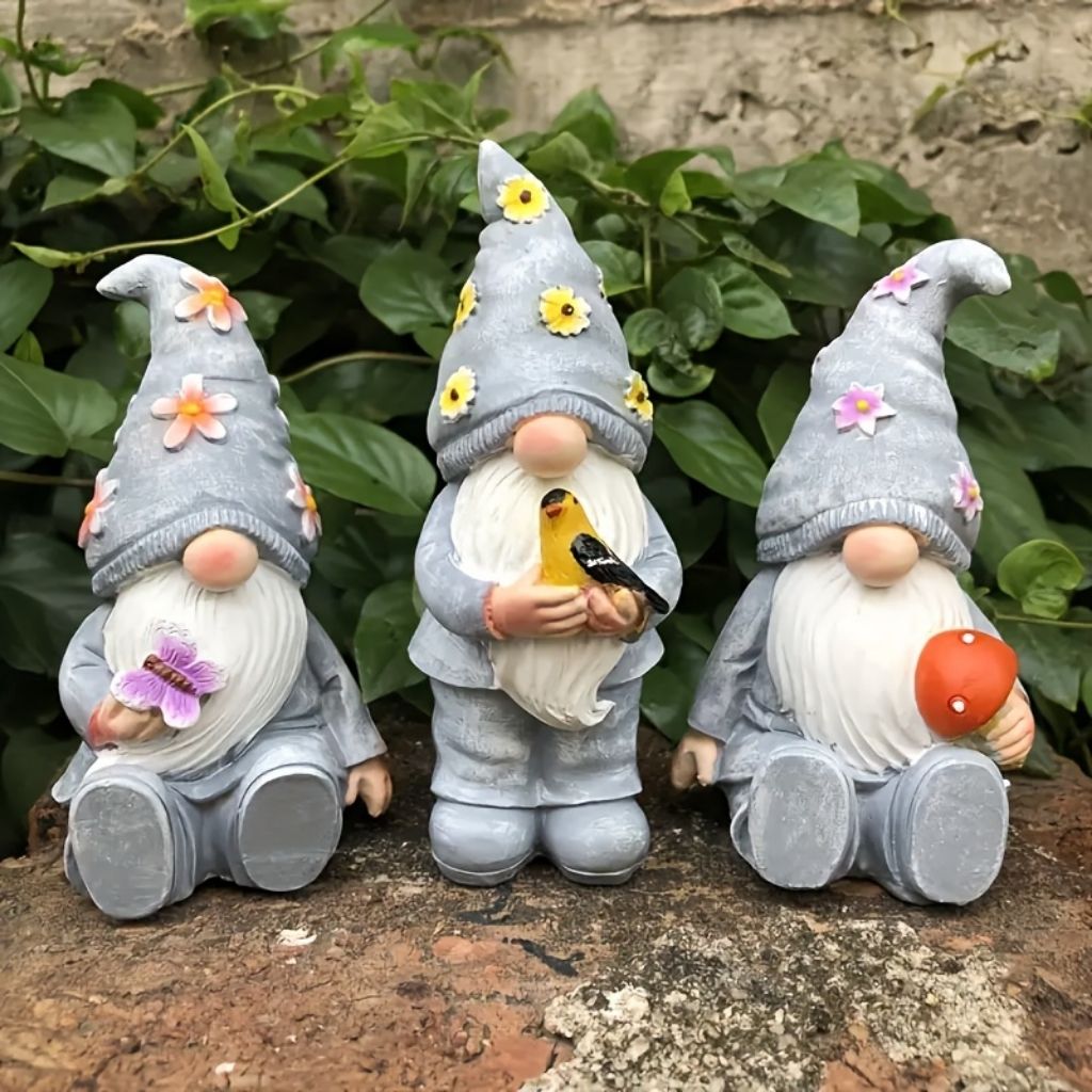 Close up of three resin gnomes with detailed facial features and colorful painted hats