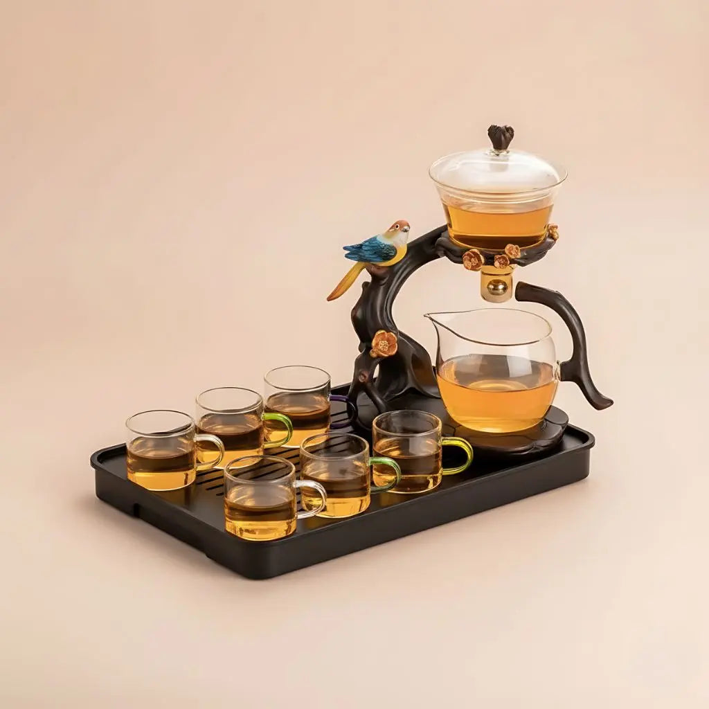 Tea set with glass cups and teapot on a tray, featuring a decorative bird ornament.