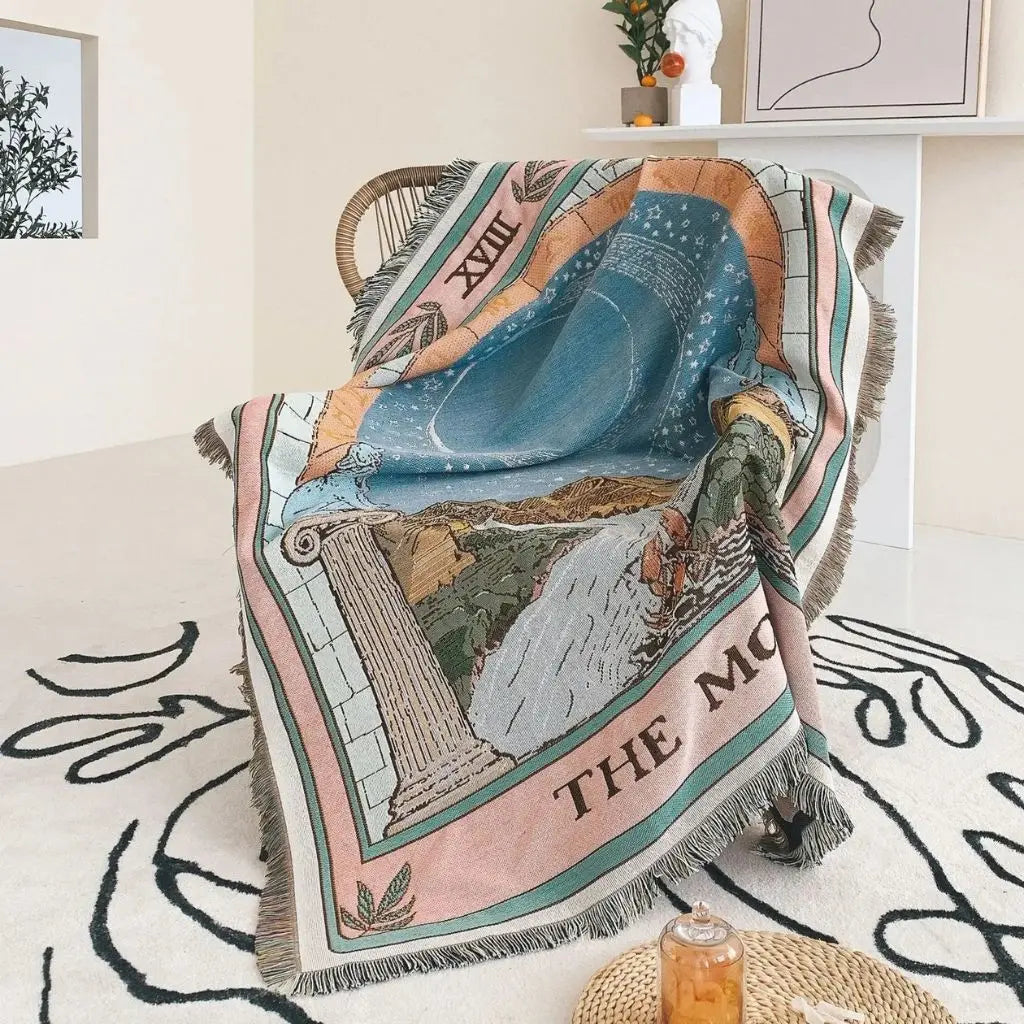 Decorative blanket with artistic design draped over a chair in a room.