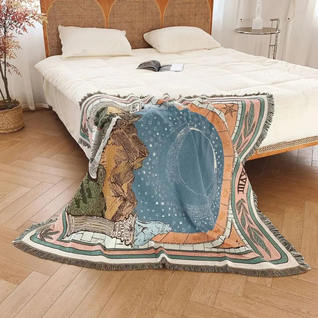 Decorative blanket with a celestial design draped over a bed in a bedroom.