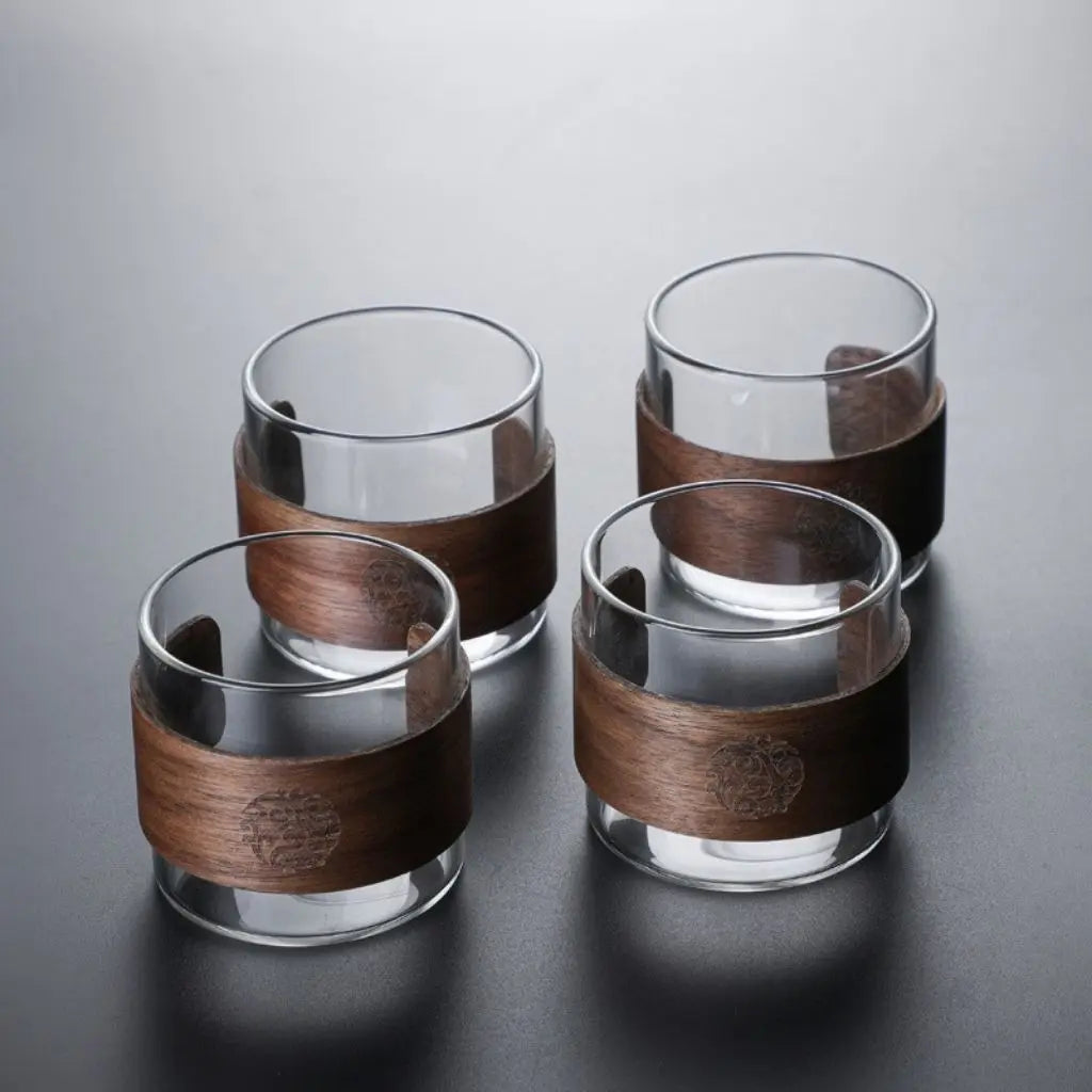 Glass tea brewing cup with walnut wood handle, combining heat resistance and elegant tea accessories design