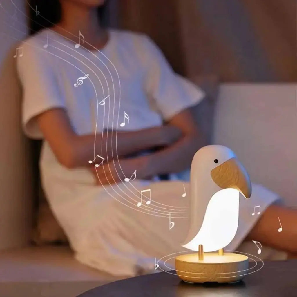 White duck-shaped night light on a table with a blurred person sitting in the background.