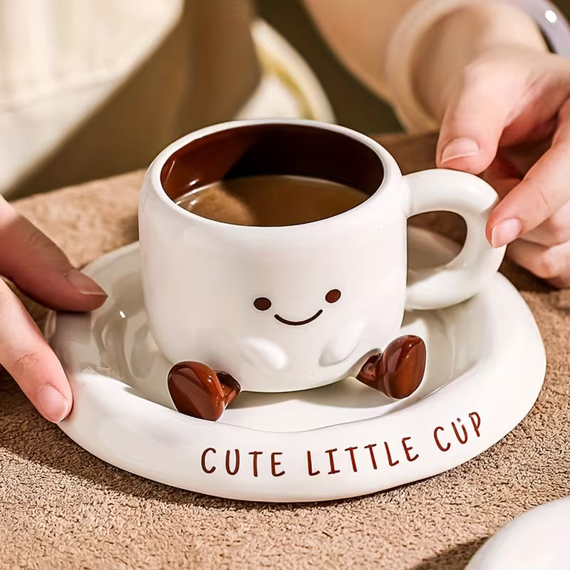 Cute white mug with a smiley face on a matching saucer, held by hands.
