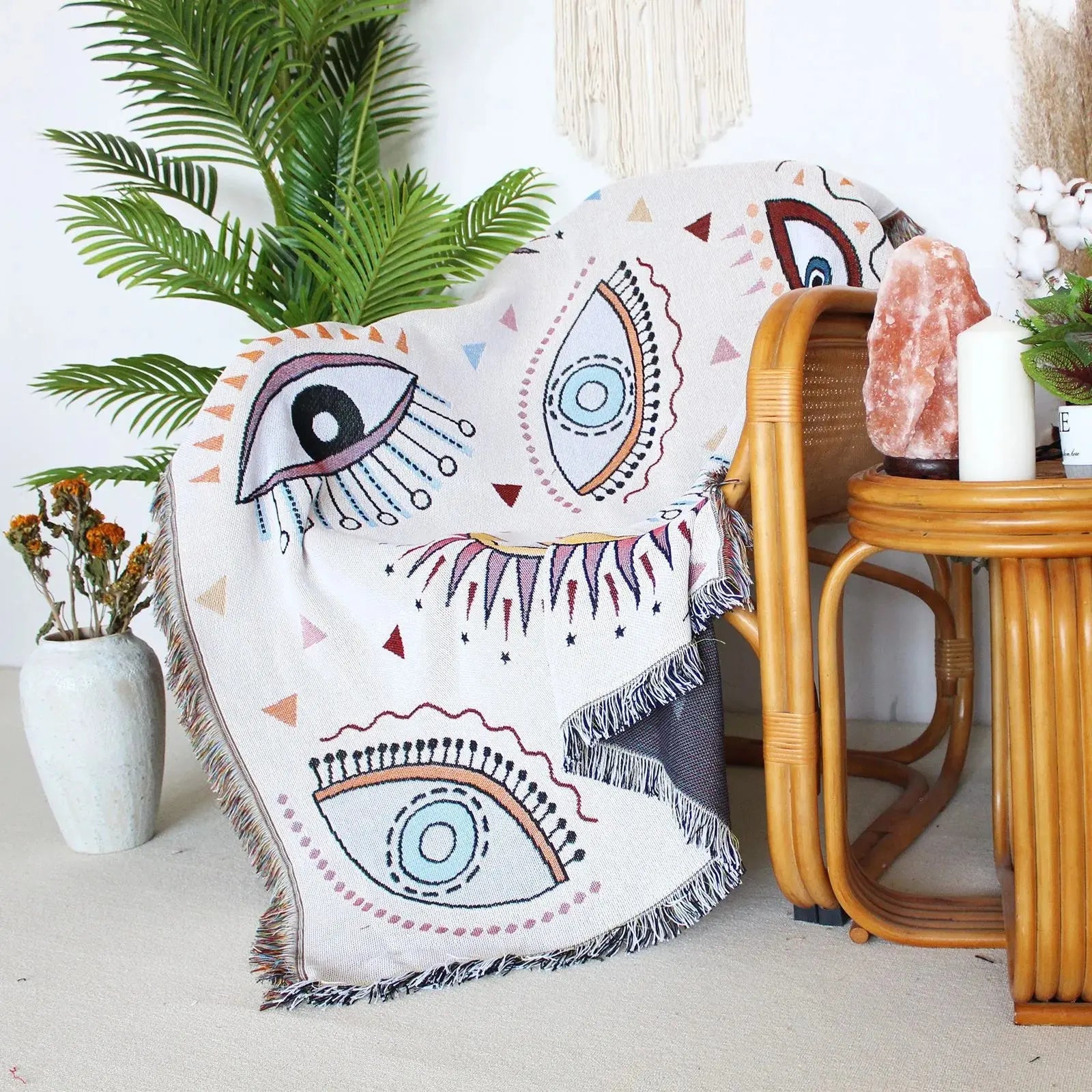 Decorative throw blanket with eye pattern on a chair in a home setting