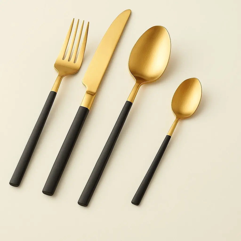 Gold stainless steel flatware set with black handles featuring knife, fork, spoon, teaspoon for dining
