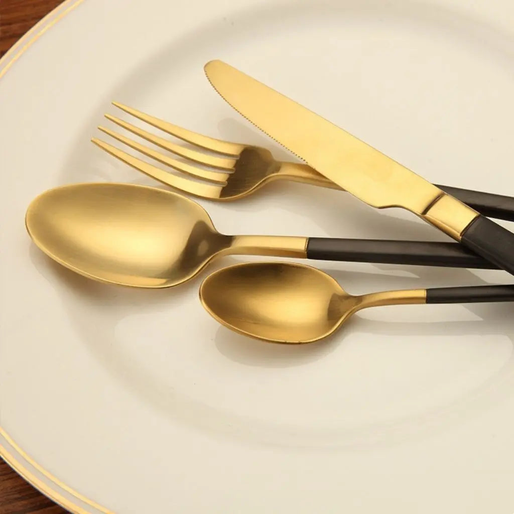 Complete 4-piece gold flatware collection including essential dining utensils with black accents