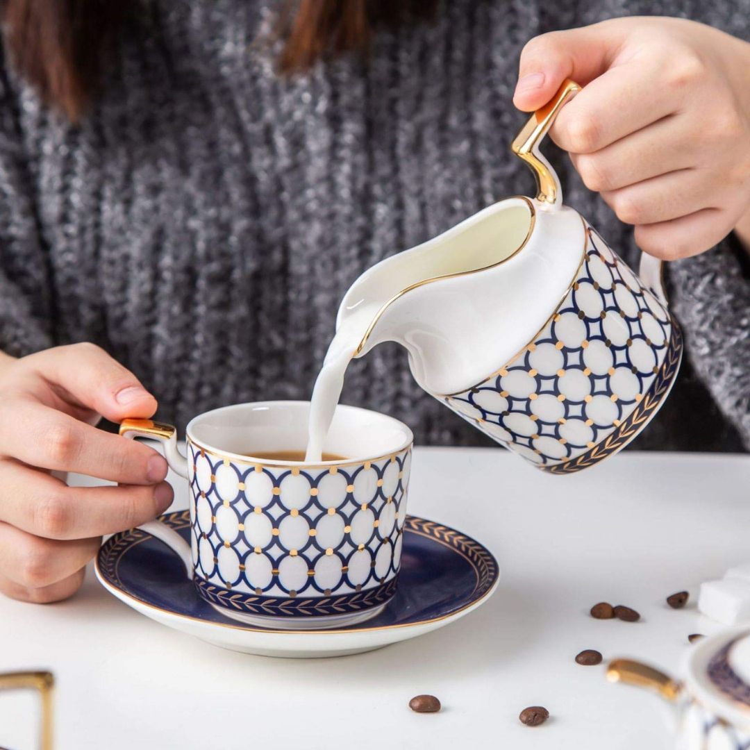 Porcelain tea service with bone china coffee cups and white ceramic teapot