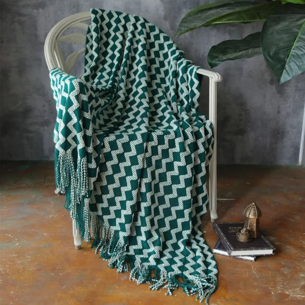 Knitted chenille blanket with textured geometric design and fringe detail for home decor