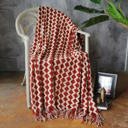 Chenille knit throw blanket featuring bold geometric pattern with decorative tasseled border