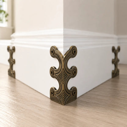 Decorative corner bracket on a white baseboard with a neutral background