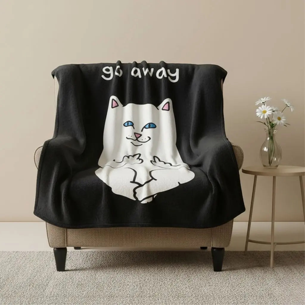 Black blanket with a cartoon cat design and 'go away' text draped over a chair in a room.