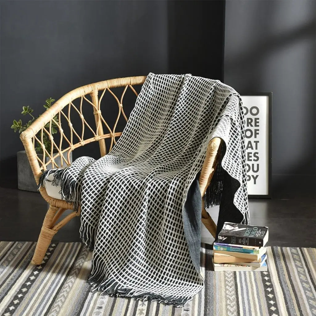 Woven throw blanket with fringed edges and tassel details for modern sofa styling