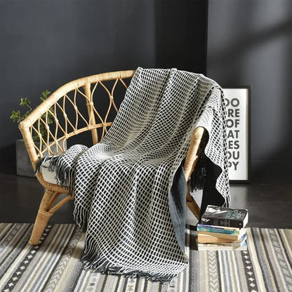 Woven throw blanket with fringed edges and tassel details for modern sofa styling