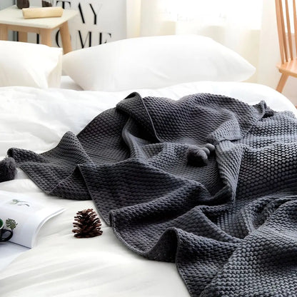Soft knit blanket with tassel edge designed for lounging and home comfort