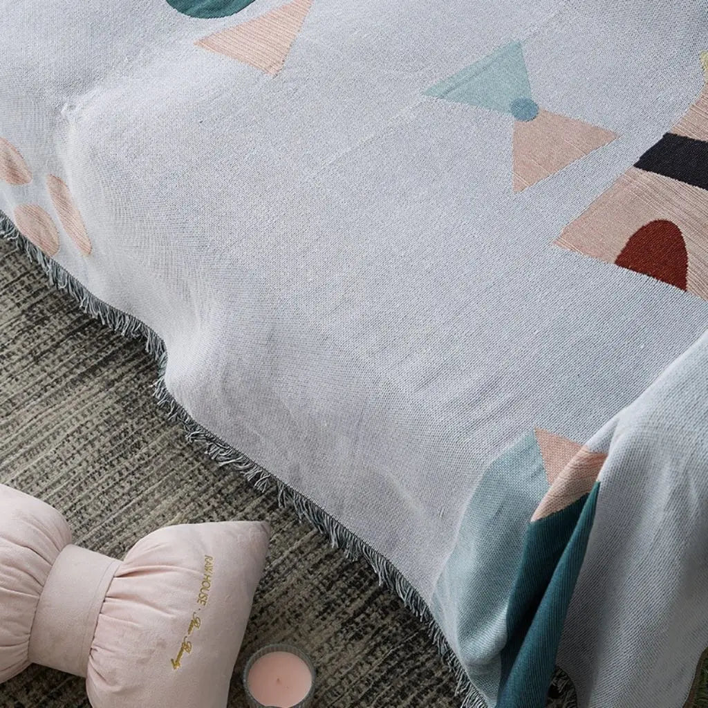 Geometric throw in cotton polyester blend with artistic shapes and soft colors