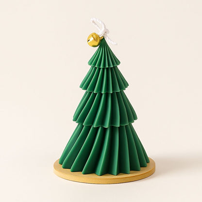 Spiral Christmas tree candle with tiered layers and decorative bell accent on white surface