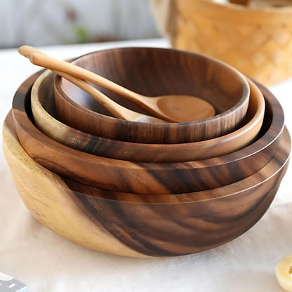 Set of wooden bowls with a wooden spoon on a light background