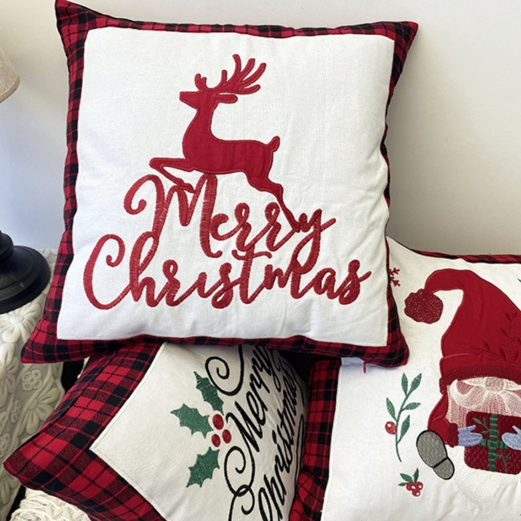Holiday throw pillow with stitched seasonal motif and contrasting plaid border