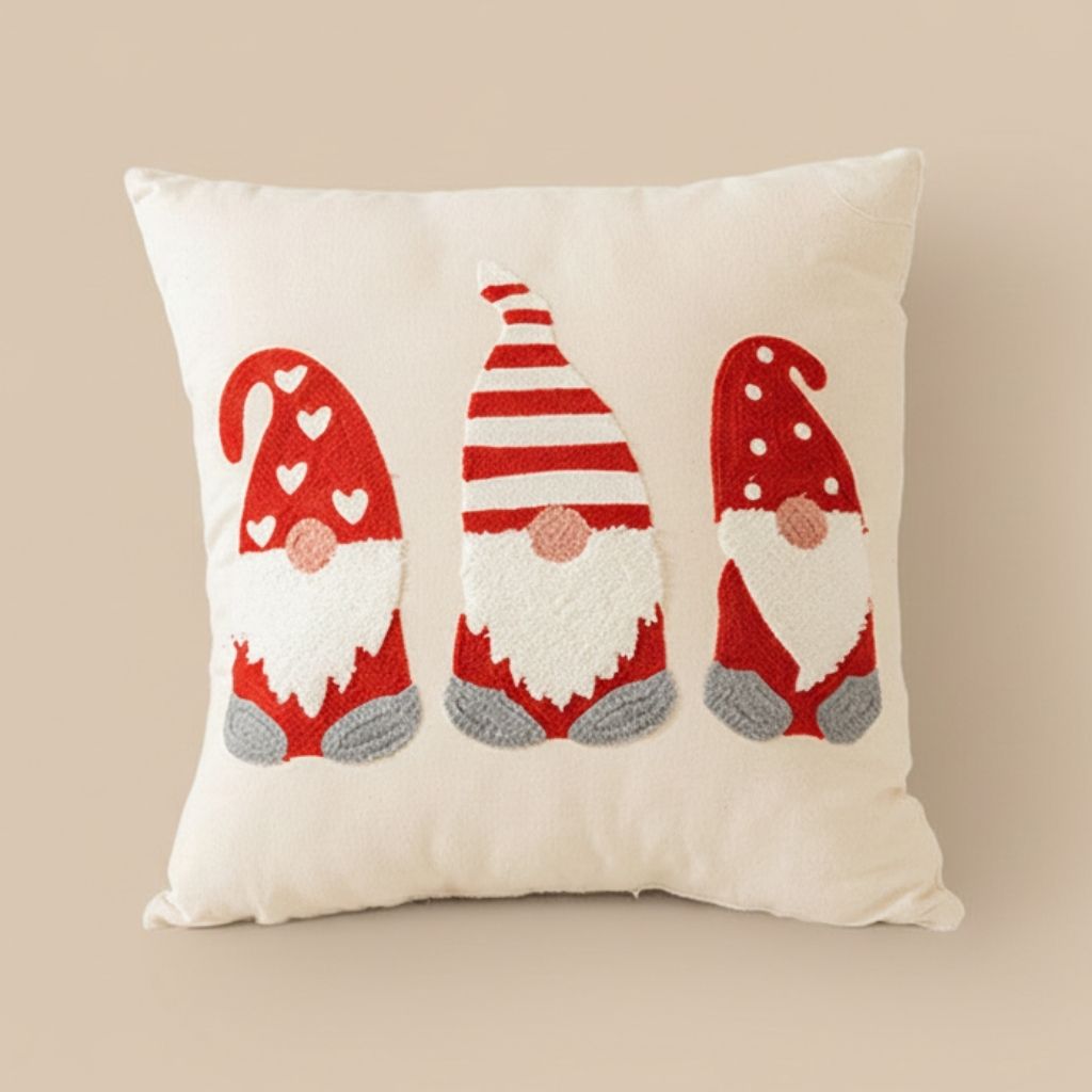 Red embroidered pillow cover with holiday motifs on beige sofa