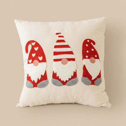 Red embroidered pillow cover with holiday motifs on beige sofa