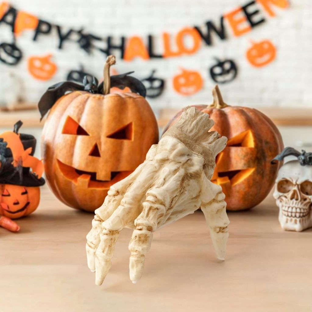 Halloween-themed decorations including carved pumpkins and a skeleton hand on a wooden surface.