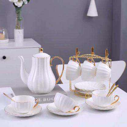 Six piece ceramic tea set with gold accents displayed on metal holder rack for organized storage