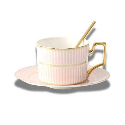 White porcelain teacup with gold handle and geometric rim detail