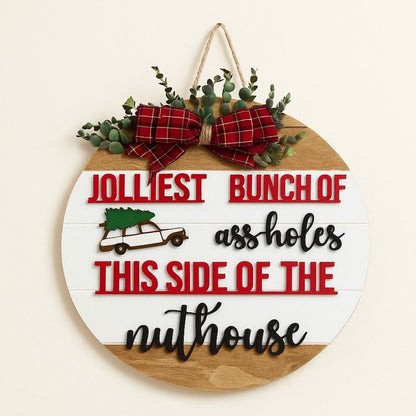 Wooden door hanger with festive holiday design and personalized name detail