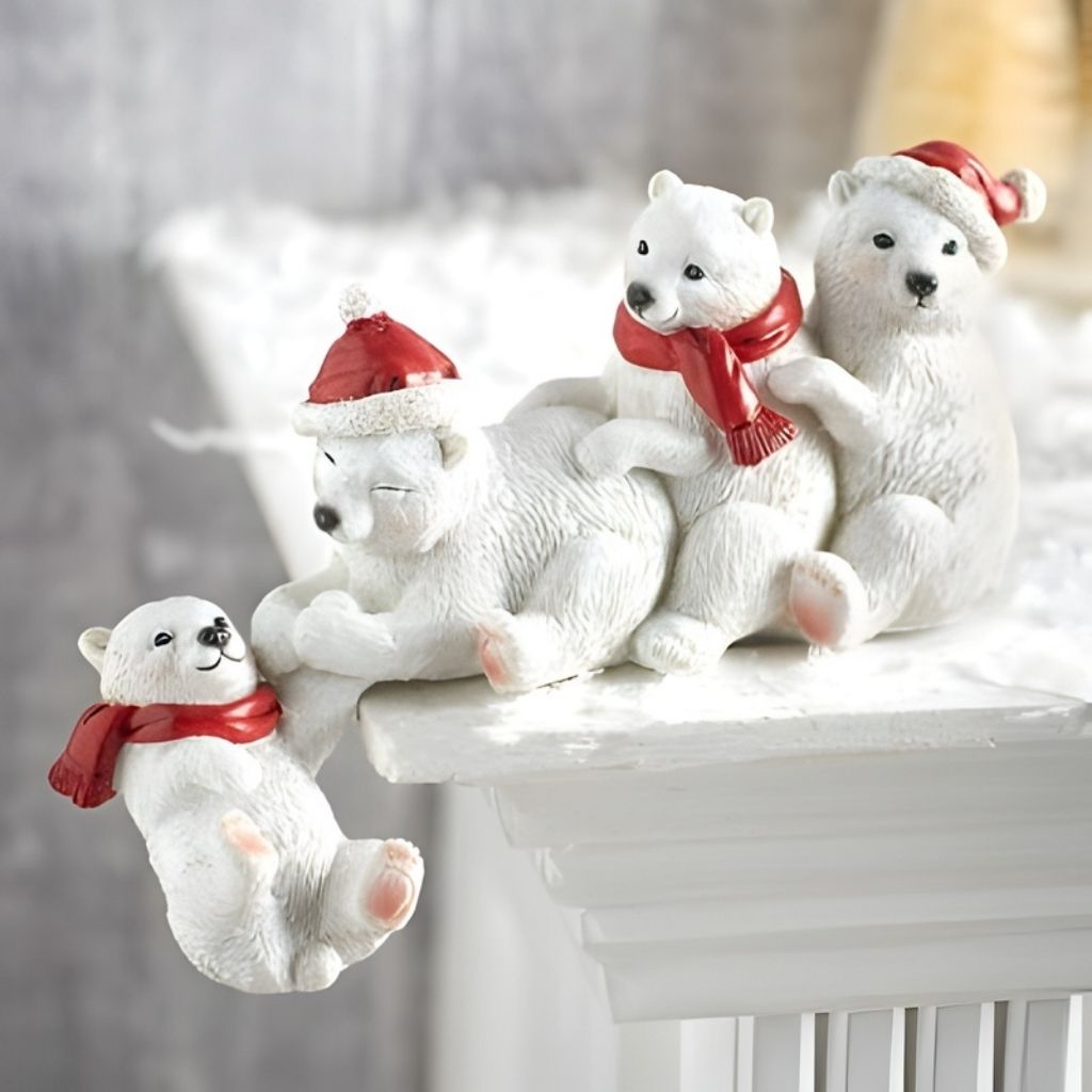 Set of white polar bear figurines with red scarves and hats on a decorative stand.