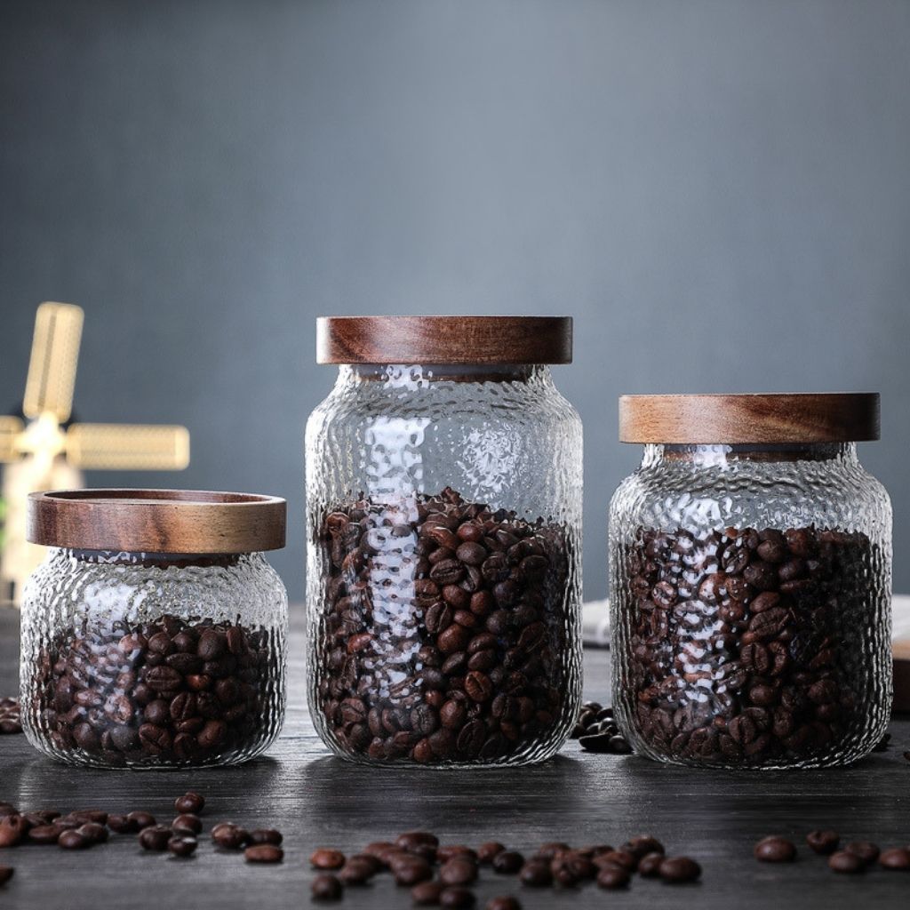  Glass canister with natural wood lid offering stylish storage solution for home kitchens.