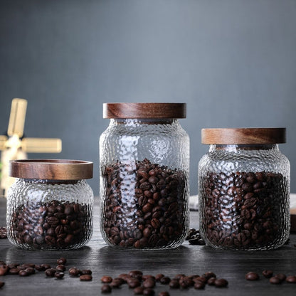  Glass canister with natural wood lid offering stylish storage solution for home kitchens.