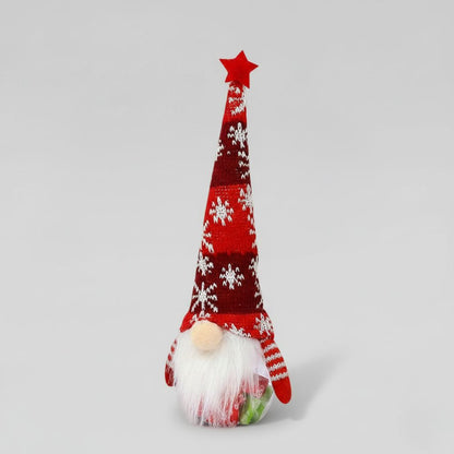 Knitted gnome with a red hat and white snowflake pattern on a gray background