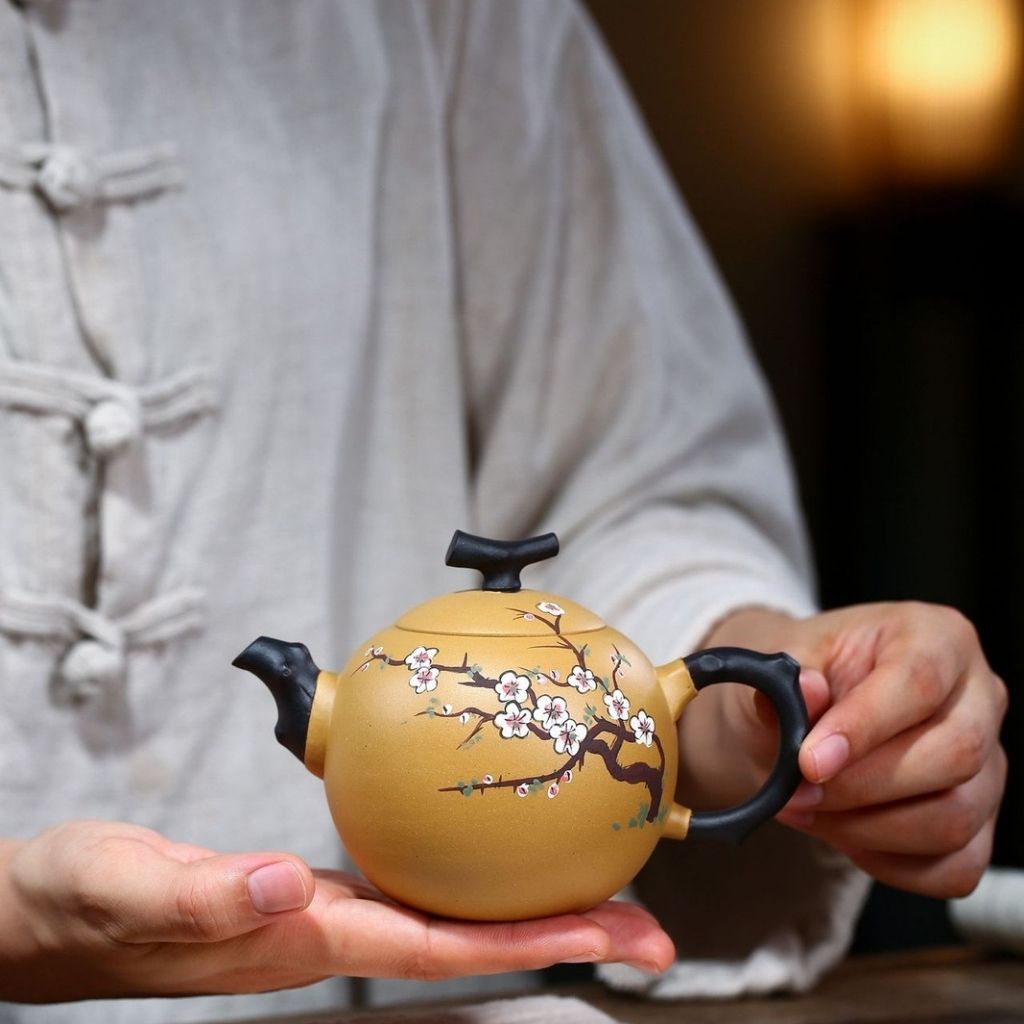 Close up of balanced spout and plum blossom relief on purple sand teapot