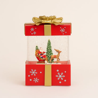 Holiday table light shaped like wrapped present with LED snow effect