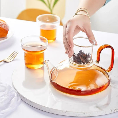 Glass tea set with teapot and cups for hot beverage serving and tea ceremonies