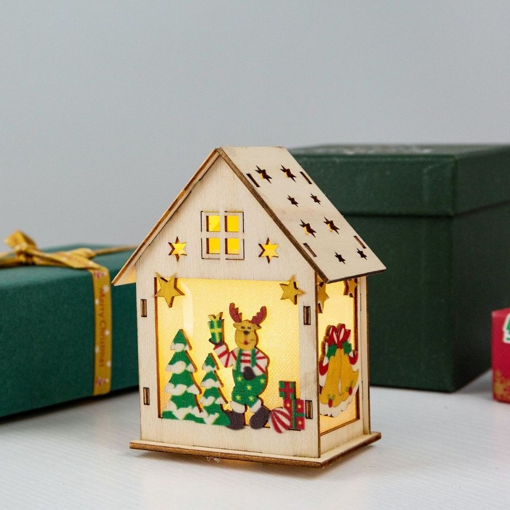 Wooden house-shaped lantern with Christmas design on a light background