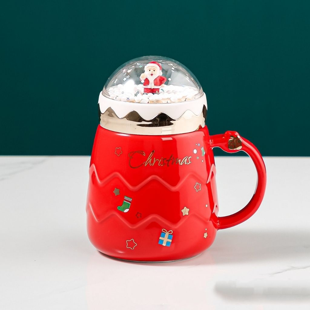 Ceramic Christmas mug with decorative snow globe topper and rounded body design