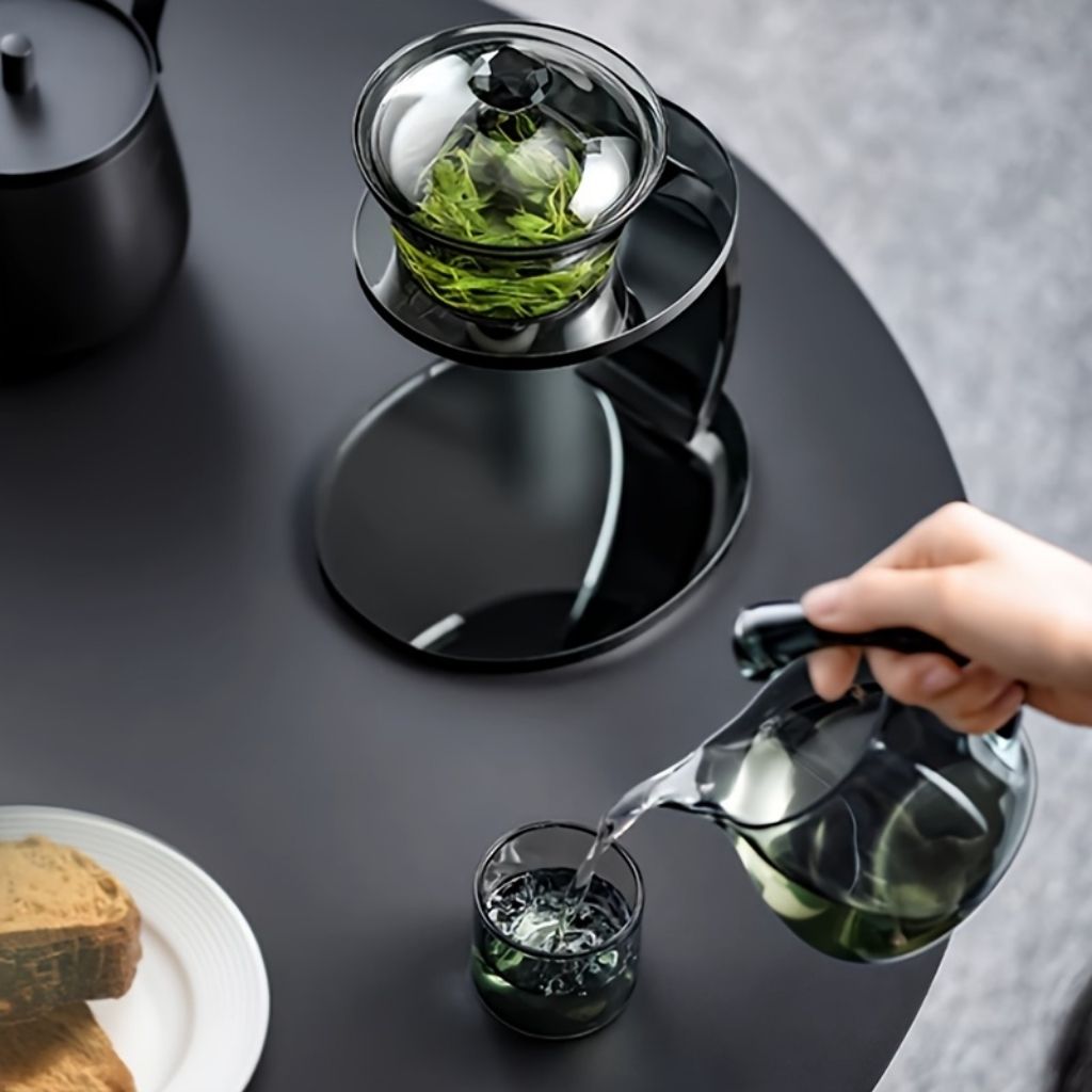 Elegant automatic tea maker with heat resistant glass construction and matching cup set for office use 