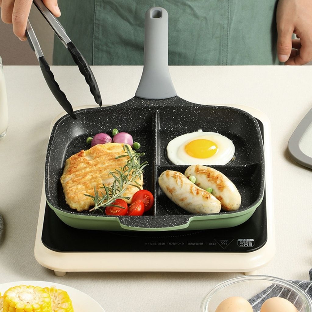 Divided skillet with four sections and composite bottom for even heat distribution during meal preparation