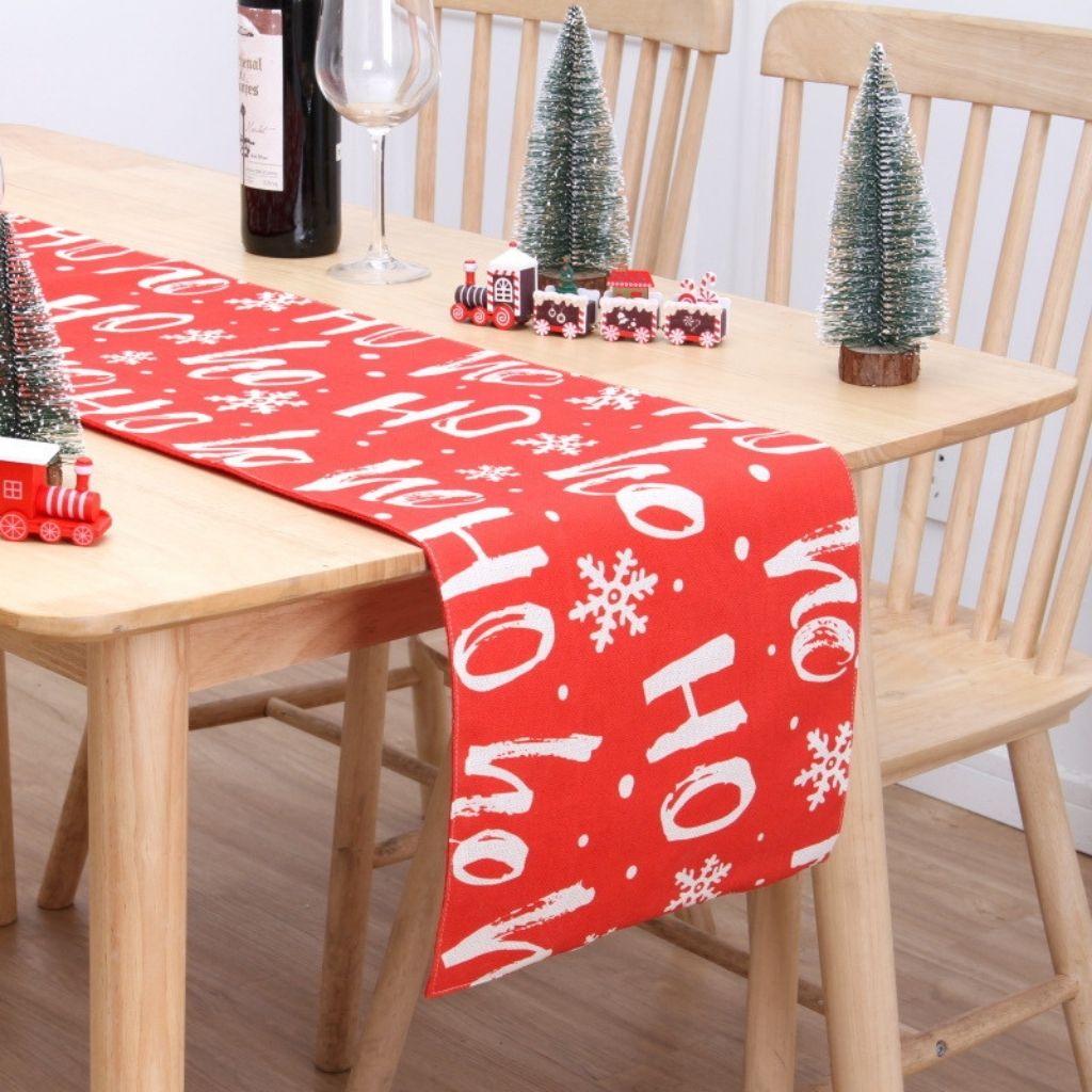 Holiday table runner with soft flannel texture draped across wooden dining surface
