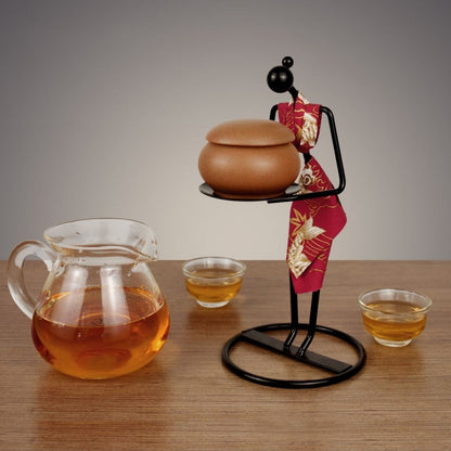 Asian tea ceremony art piece with iron figure holding traditional glass teacup